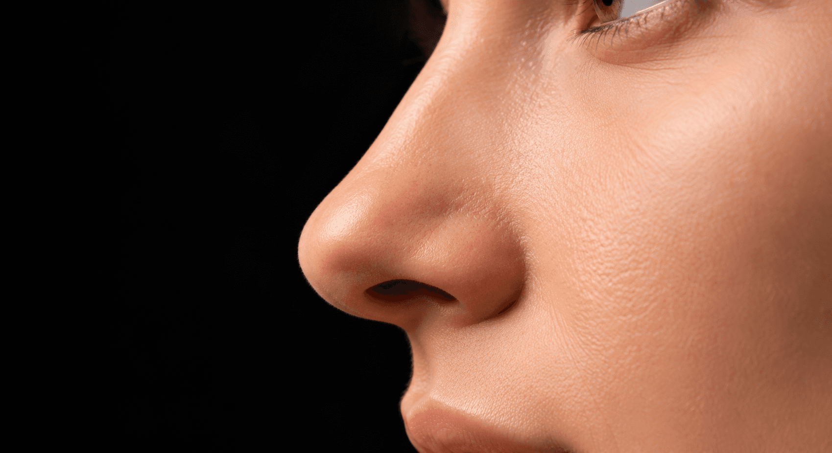 Close-up monochrome profile view of refined aesthetic nasal contours, demonstrating subtle natural projection and dorsal balance from corrective cosmetic rhinoplasty.